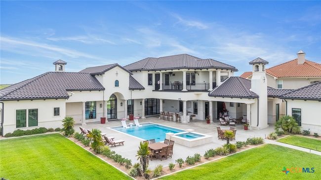 Aerial View of the Loggia with the Outdoor Kitchen, Fireplace, Pool, Hot Tub, and Poolside Seating Area along with the Second Level Balcony | Image 42