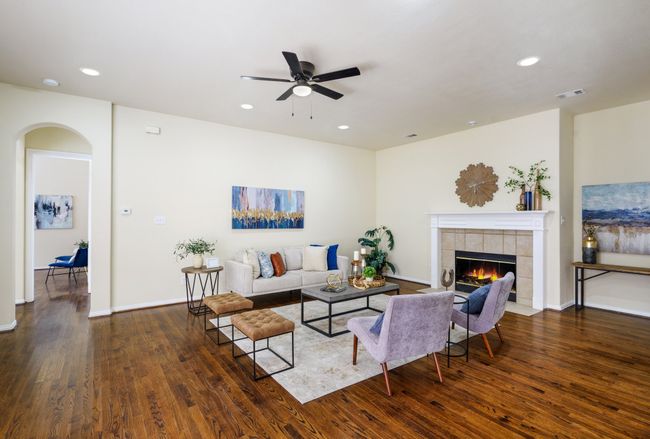 Living area with baseboards, a fireplace, ceiling fan, recessed lighting, and wood floors | Image 9