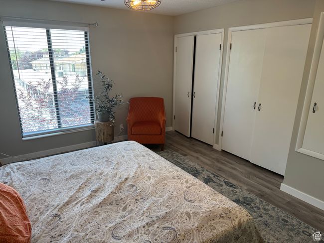 Bedroom featuring multiple closets, multiple windows, and wood finished floors | Image 18