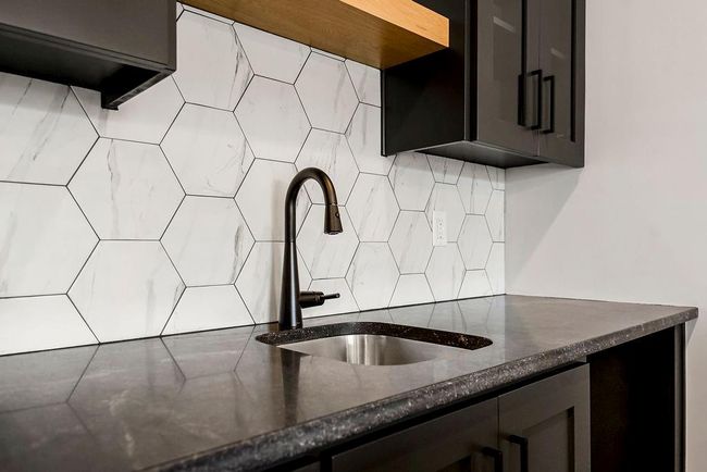 Kitchen featuring a sink, decorative backsplash, and dark stone countertops | Image 33