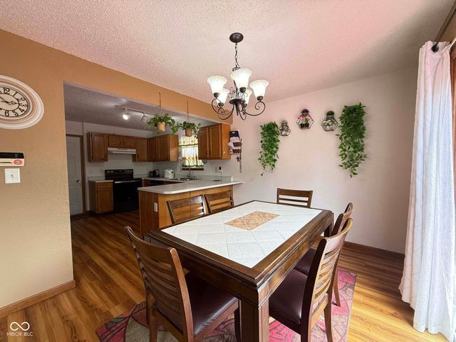 dining space with a chandelier, a textured ceiling, and dark wood-style floors | Image 22