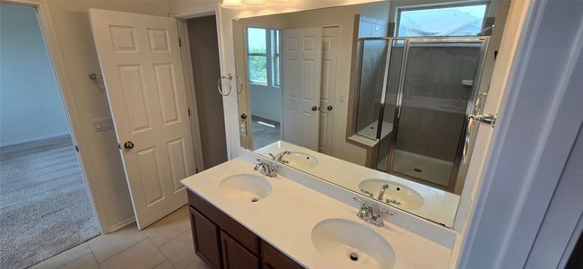 Bathroom featuring a shower stall, double vanity, and tile patterned floors | Image 19
