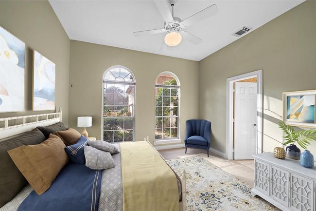 The downstairs bedroom features an en suite bath and large windows that provide stunning front estate views and flood the room with natural light. | Image 40