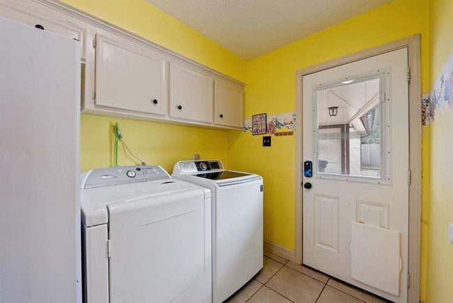 Bright and cheery utility room has door to the back with a digital lock. | Image 16