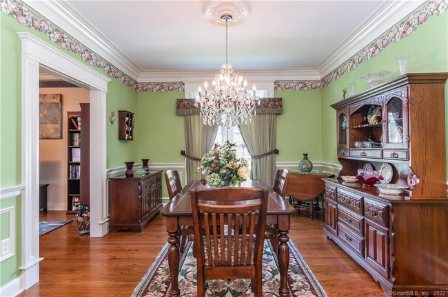 Dining room has a chair rail , crown molding, and a crystal chandelier with ceiling medallion. | Image 20