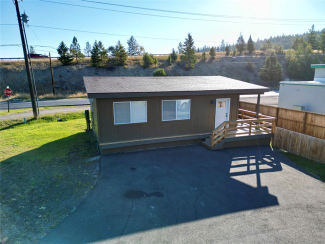 View of front facade featuring a shingled roof, a front yard, and fence | Image 19
