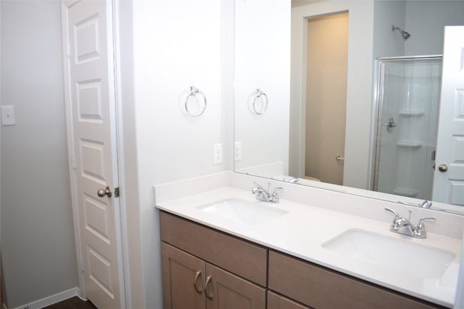 Bathroom featuring a stall shower and double vanity | Image 12