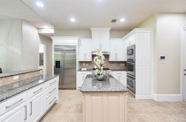Spacious white kitchen makes this Chef's kitchen offers a touch of class and grace. | Image 19
