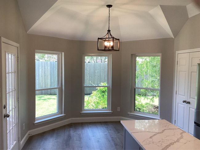 Unfurnished dining area featuring a chandelier, vaulted ceiling, healthy amount of natural light, and dark wood-style floors | Image 9