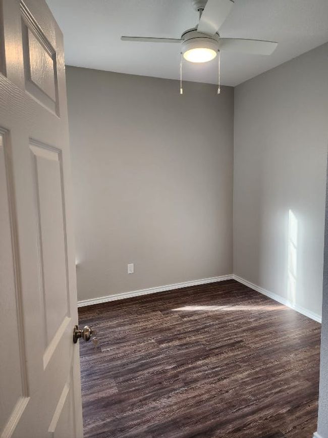 Unfurnished room featuring a ceiling fan, dark wood-style flooring, and baseboards | Image 8