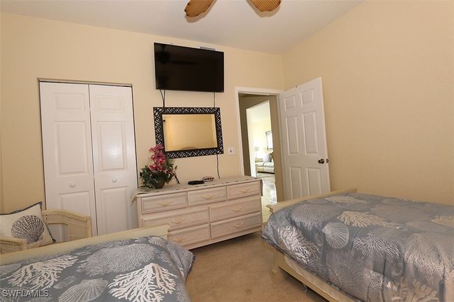 Bedroom with a closet, ceiling fan, and light colored carpet | Image 17