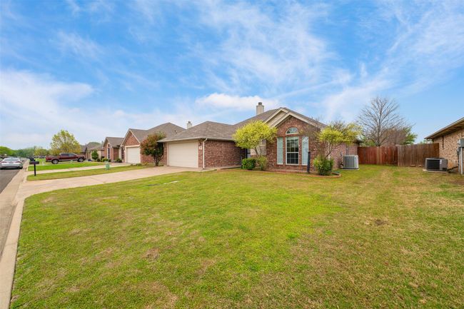 Ranch-style house with driveway, a front yard, brick siding, a garage | Image 22