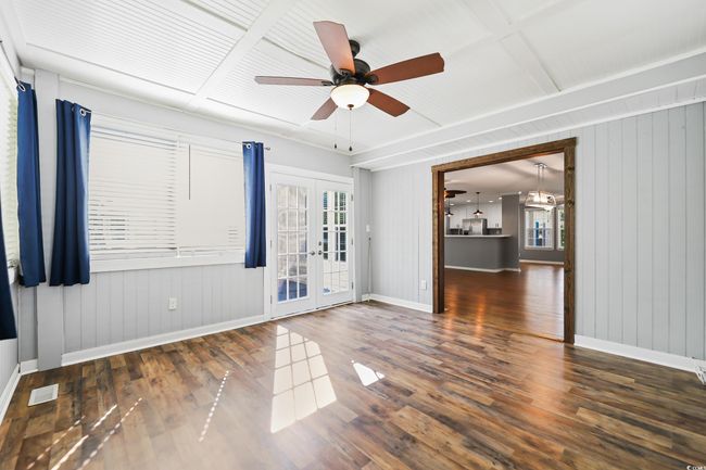 Spare room with french doors, baseboards, a ceiling fan, wood finished floors, and wood walls | Image 17