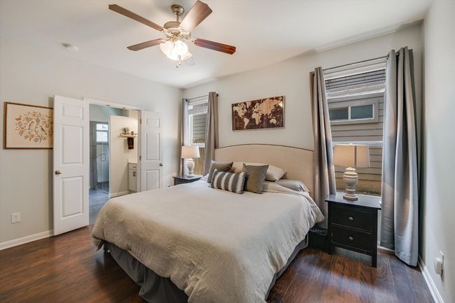 Bedroom with wood finished floors, baseboards, connected bathroom, and ceiling fan | Image 16