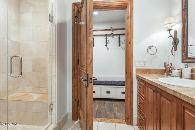 A convenient bath just off the mudroom and guest wing provides quick access after ski days or village strolls, with artisan tile and rustic mountain charm. | Image 9