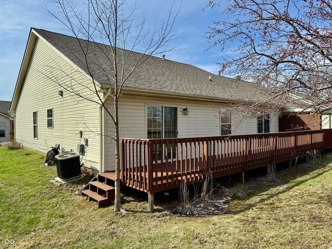 back of house featuring a yard, central AC, a deck, and a shingled roof | Image 15