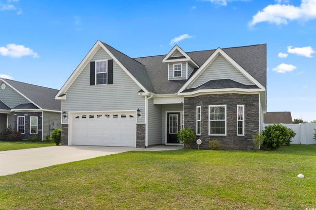Craftsman inspired home with fence, a front yard, stone siding, a shingled roof, and concrete driveway | Image 37