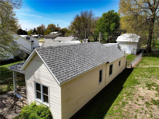 View of side of property featuring a lawn, fence, and roof with shingles | Image 32