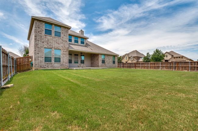 Back of property featuring a fenced backyard, brick siding, a chimney, and a shingled roof | Image 28