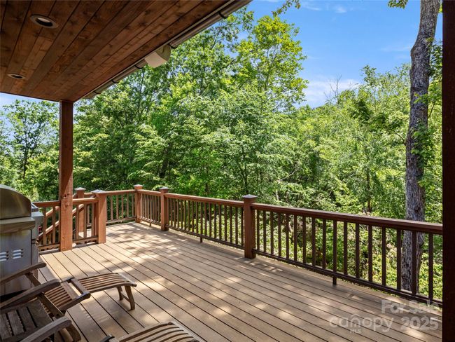 Partially covered deck provides sun and rain protection while grilling or relaxing and enjoying the private landscape views. | Image 20