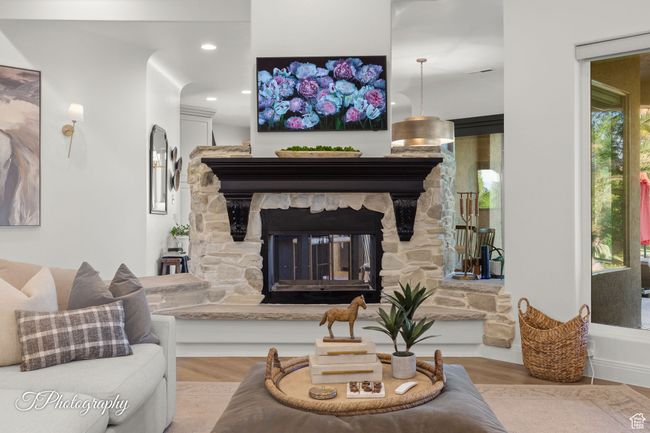 Living area featuring wood finished floors, a stone fireplace, and recessed lighting | Image 44