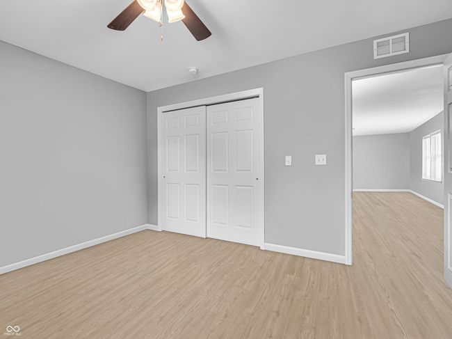 spacious bedroom #3 with vinyl plank flooring and a ceiling fan | Image 18
