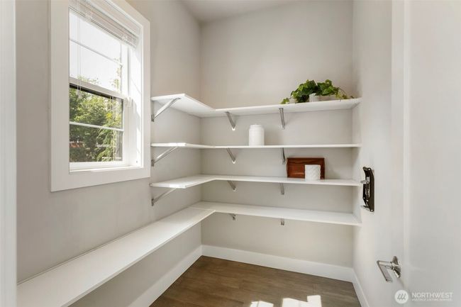 This spacious walk-in pantry offers generous open shelving and natural light, making it as functional as it is inviting. Perfectly positioned off the kitchen, it keeps everyday essentials organized and easily accessible. | Image 17