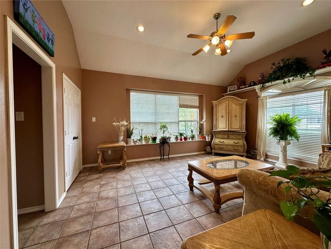 Sitting room featuring lofted ceiling, recessed lighting, light tile patterned floors, baseboards, and a ceiling fan | Image 12