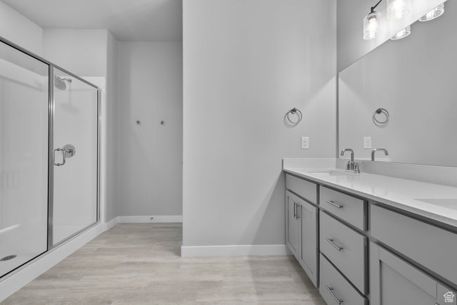 Full bathroom with double vanity, wood finished floors, and a stall shower | Image 10