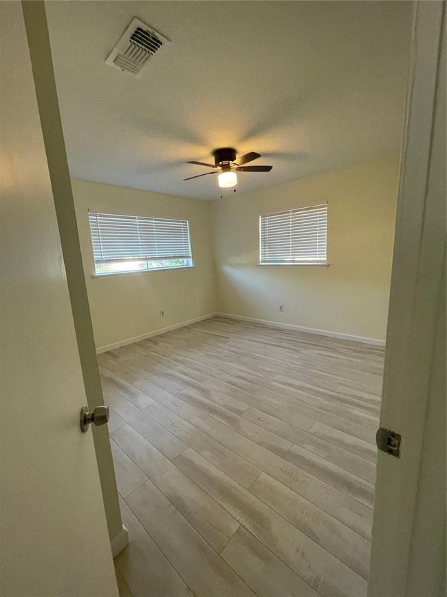 Spare room with light wood finished floors, baseboards, and ceiling fan | Image 12