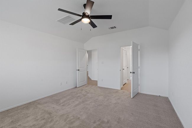Unfurnished bedroom featuring vaulted ceiling, light carpet, and a ceiling fan | Image 12