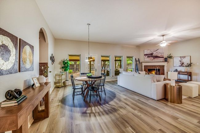 Dining area featuring wood finished floors, a fireplace, and a ceiling fan | Image 21