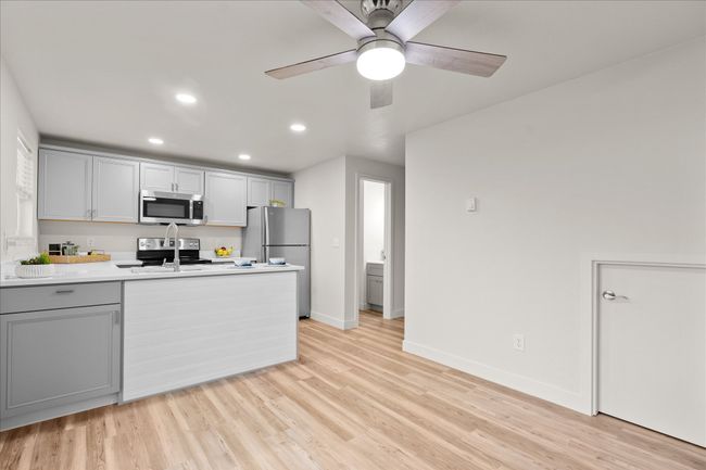 Kitchen with gray cabinets, recessed lighting, light wood-style flooring, and light countertops | Image 10