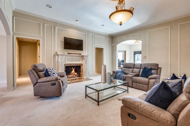 Living room with light carpet, ornamental molding, arched walkways, and a decorative wall | Image 11