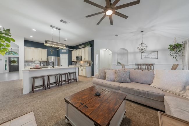 Living room with arched walkways, ceiling fan, recessed lighting, and light carpet | Image 17