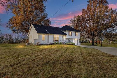 View of front facade with a garage and a lawn | Image 2