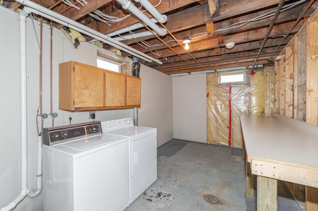 Nice washing area in lower level with cabinet space and folding table | Image 22