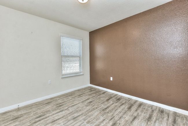 Guest Bedroom has ceiling fan and wood-look tile. | Image 25
