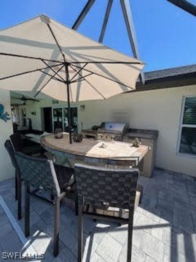 View of patio with outdoor wet bar, grilling area, and an outdoor kitchen | Image 34