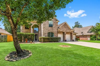 This is a spacious two-story brick home featuring a well-manicured lawn, mature shade tree, and an attached 3-car garage. The property boasts a welcoming entrance with a large window above the front door, allowing for natural light to enhance the entryway. | Image 3