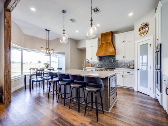 Spacious dining area at the huge bay window. All new cabinets, huge walk-in pantry, large gas cooktop. Notice the double ovens to your right, custom vent cover, and the perfectly located microwave on the side of the island. | Image 10