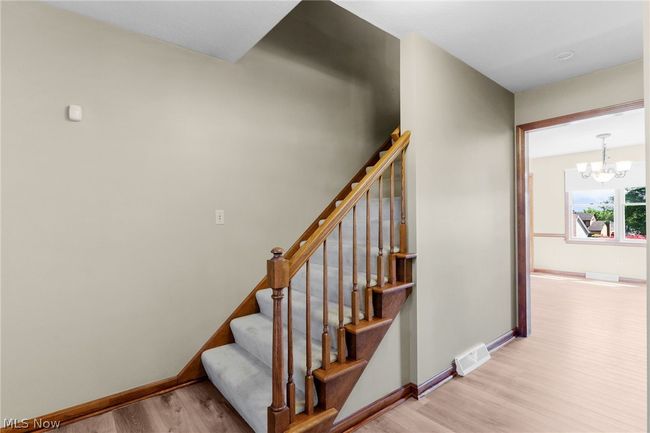 Stairway featuring light hardwood / wood-style floors and a notable chandelier | Image 8