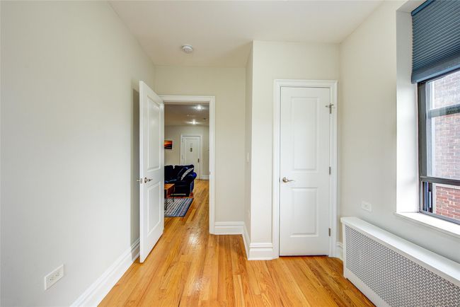 Corridor featuring baseboards, light wood-style floors, and radiator heating unit | Image 11