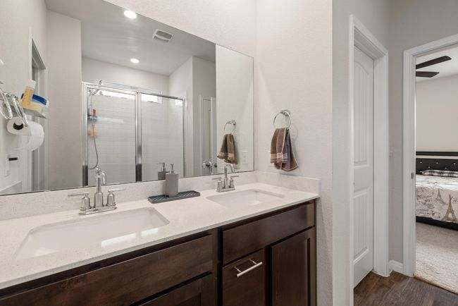 Ensuite bathroom featuring wood finished floors, double vanity, and a shower stall | Image 21