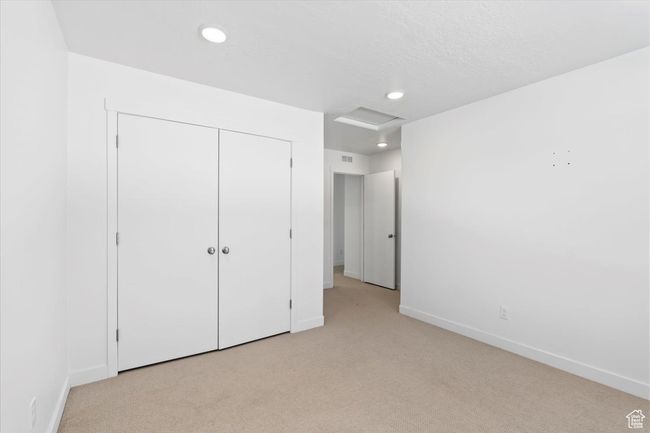 Unfurnished bedroom with light colored carpet, baseboards, recessed lighting, and a closet | Image 24