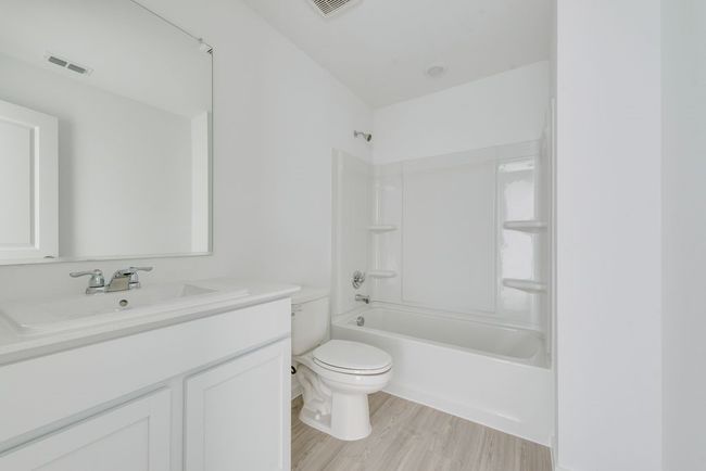 Bathroom featuring vanity, wood finished floors, and shower / bath combination | Image 18