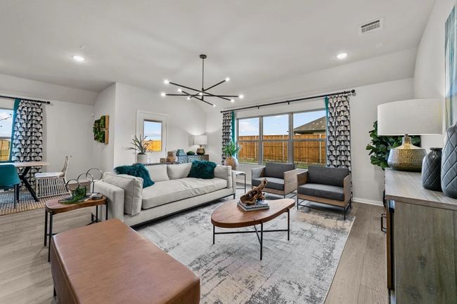 Living area with healthy amount of natural light, a chandelier, light wood-style flooring, recessed lighting, and baseboards | Image 19