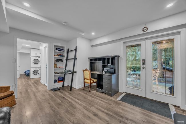 Office area with french doors, stacked washing machine and dryer, wood finished floors, and recessed lighting | Image 23