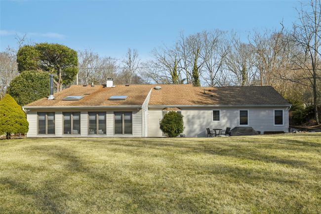 Rear view of house featuring a yard, roof with shingles, and a chimney | Image 31