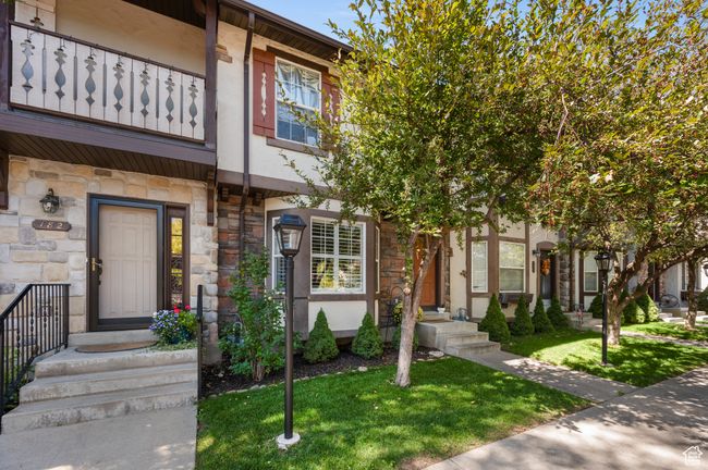 Multi unit property featuring stone siding, a balcony, a front lawn, and stucco siding | Image 27